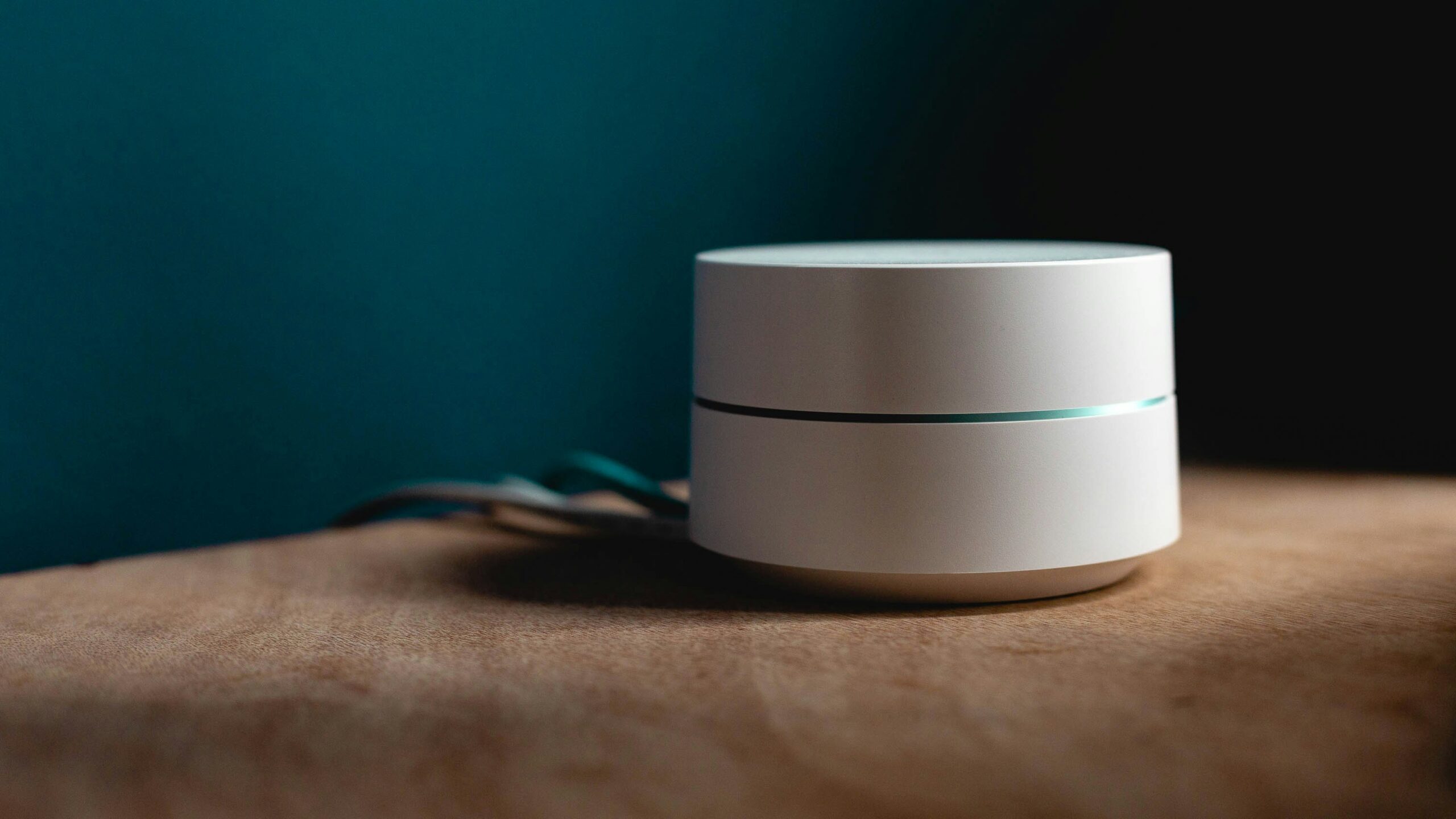 a modem router sits on top of a wooden desk supplying an internet connection.