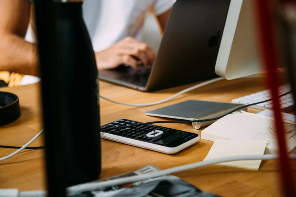 employee sits behind desk and calculates cost saving.