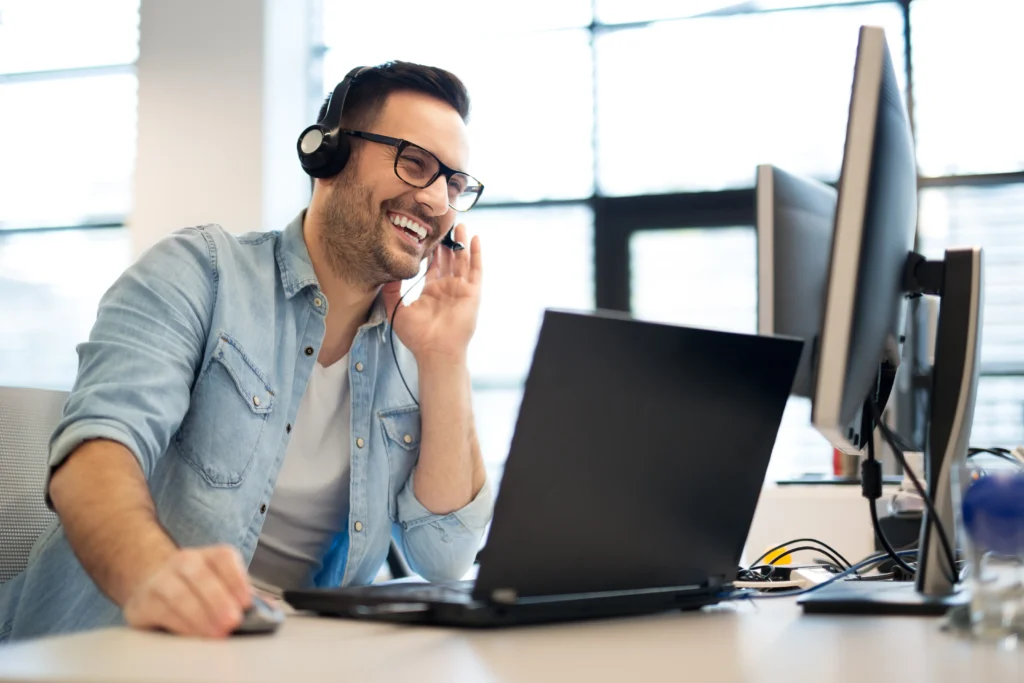 Male employee works efficiently using a VoIP phone system.