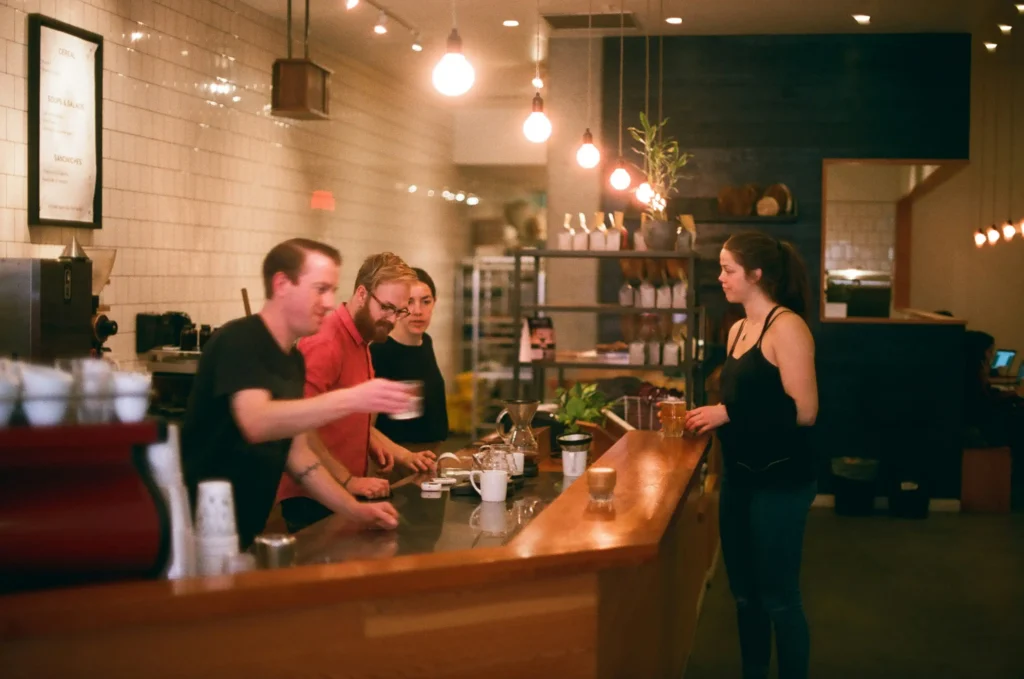  a coffee shop team works hard to keep up customer satisfaction.