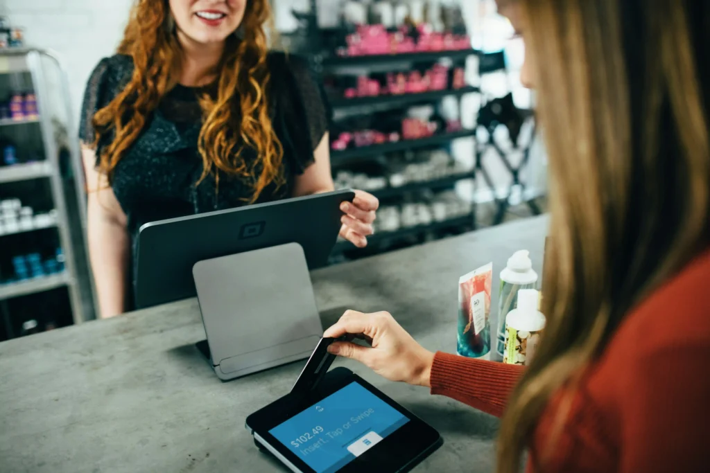 Happy female employee gives excellent customer service to female customer.